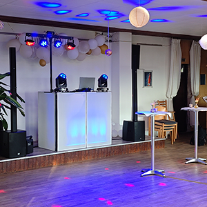 Beleuchtetes DJ Greußen Setup mit LED-Pult, Lautsprechern und Lichttechnik bei einer Geburtstagsfeier. Die ART of SOUND als DJ Greußen sorgt für stilvolle Atmosphäre mit professionellem Equipment und stimmungsvoller Beleuchtung in einem festlich dekorierten Veranstaltungsraum.
